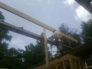 Carpenter setting a ridge beam over a new addition frame — Ice Dam Removal by Roofing Brothers in Preston
