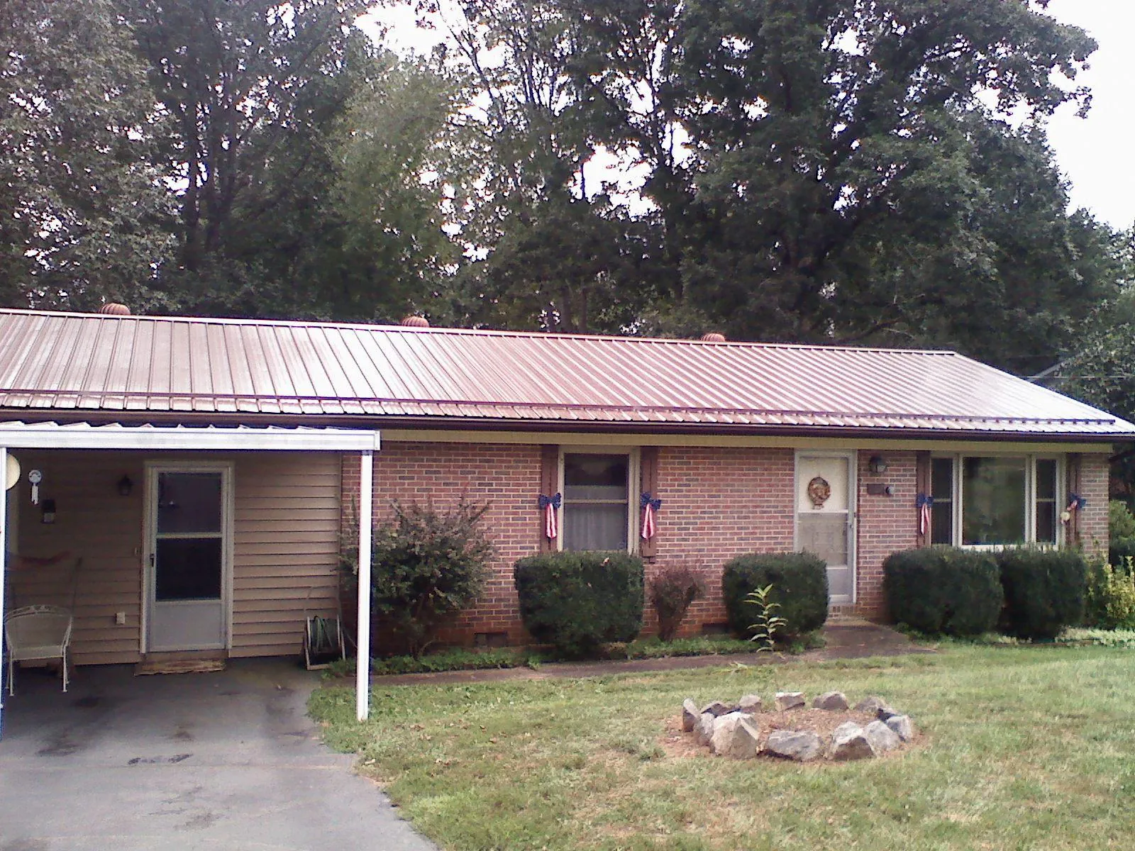 Bronze metal roof and carport on a brick ranch home — Roof Repair work by our crew in Preston